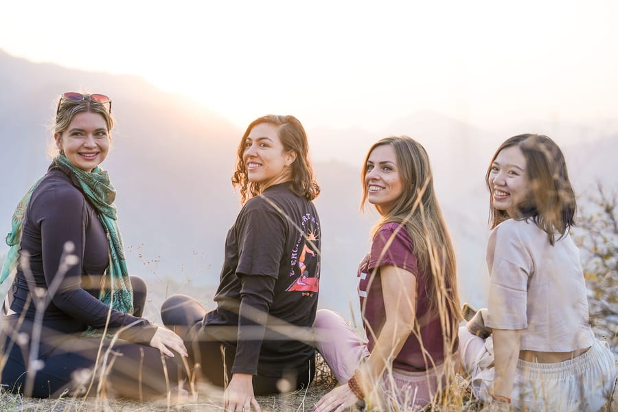 Cuatro mujeres sentadas en lo alto de un mirador al atardecer