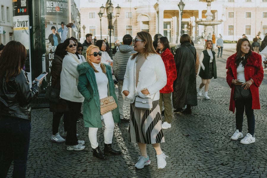 Un grupo de mujeres charlando en una plaza de una ciudad europea