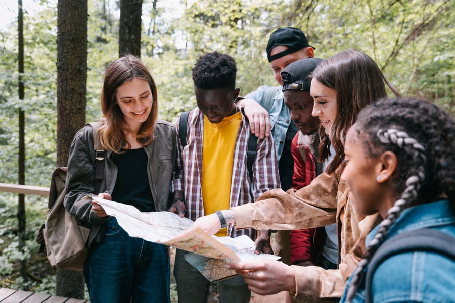 Un grupo de cinco personas alrededor de un mapa en el bosque